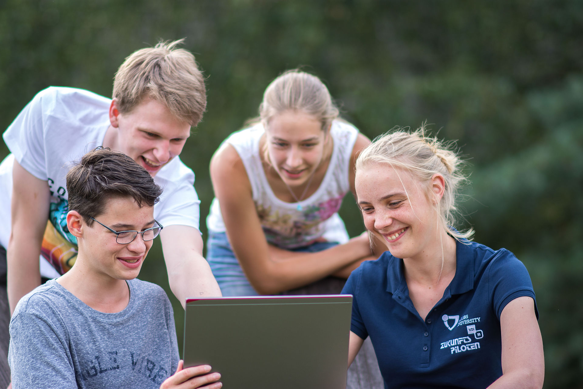 Eine Gruppe Jugendlicher vor einem Laptop